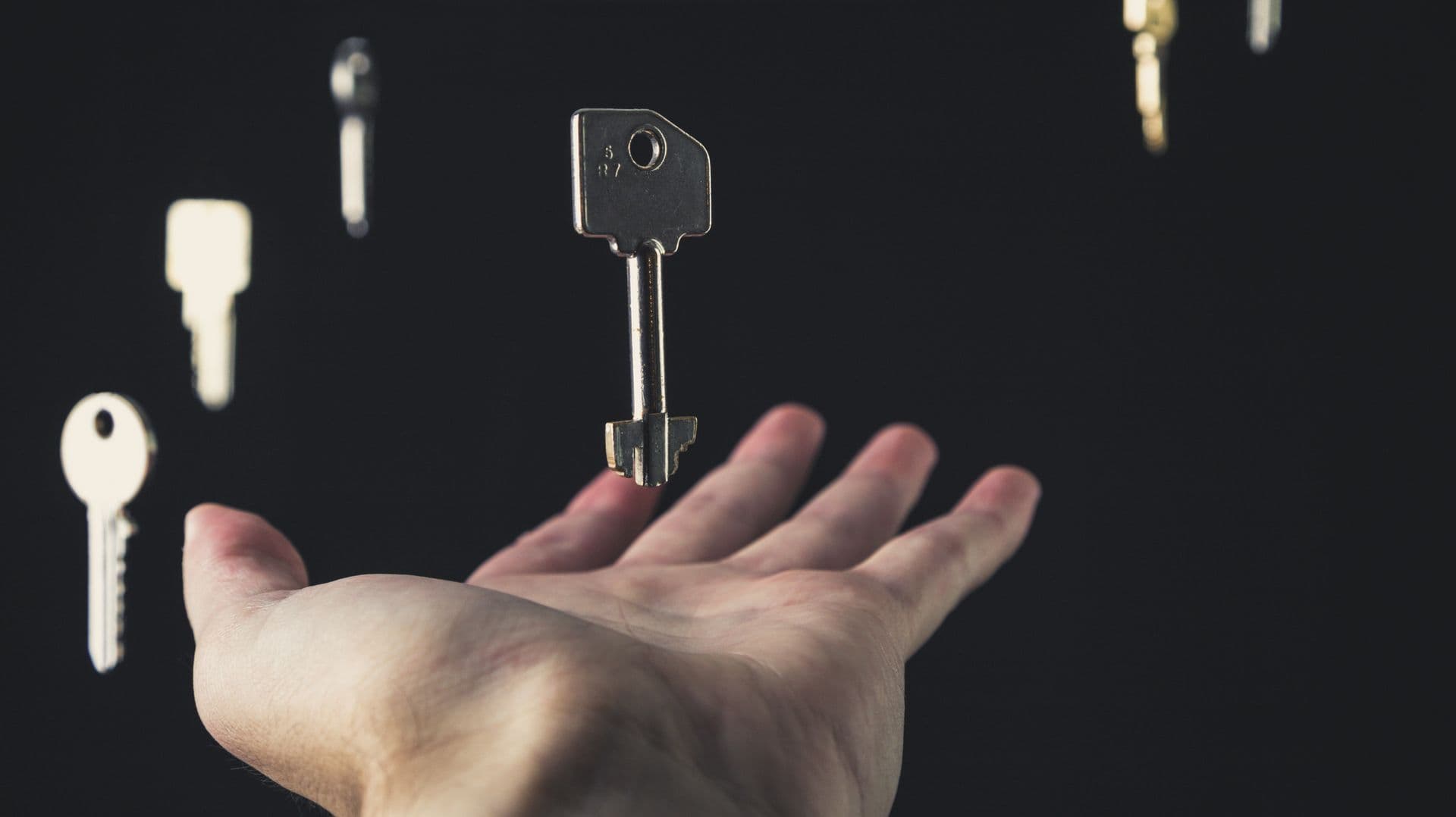 Keys above an open hand — the rekey or replace decision after moving in