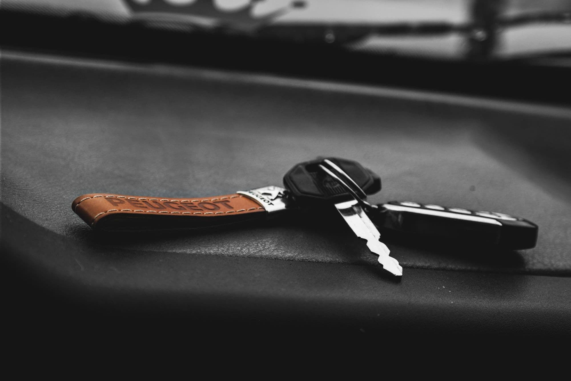 Two transponder keys on a dark surface — a blade and a chip inside each