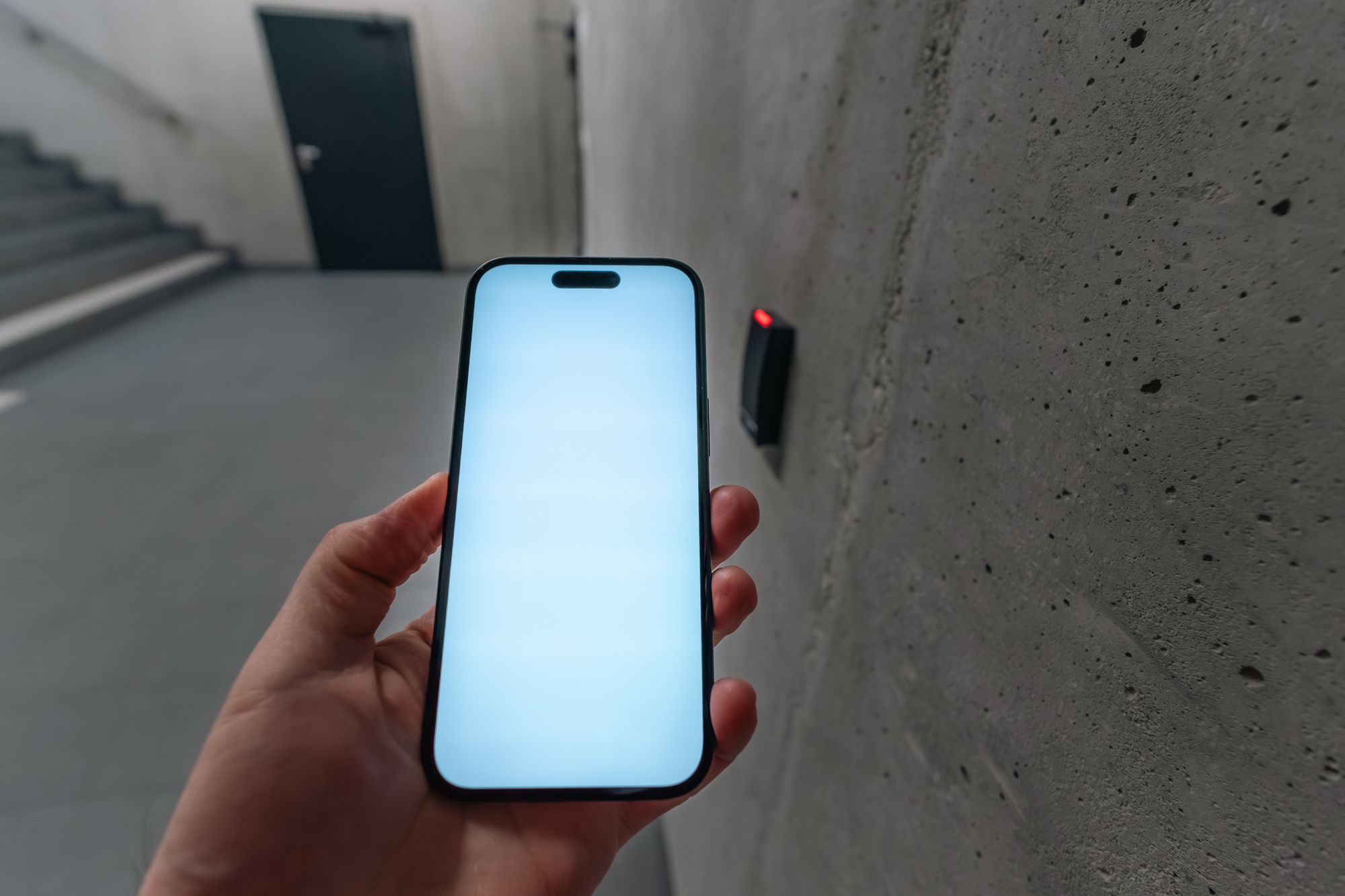 A phone held to a reader for touchless entry in a modern building