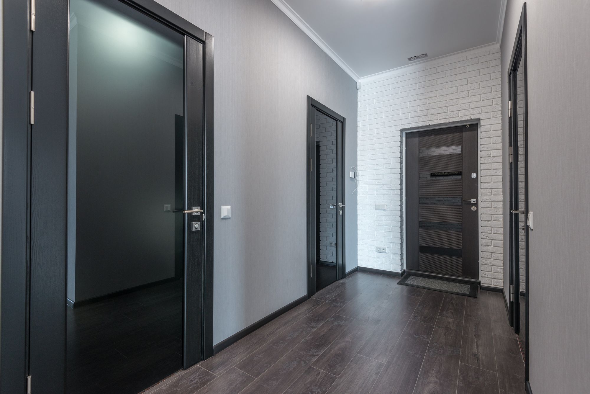 The corridor of a modern apartment building lined with unit doors