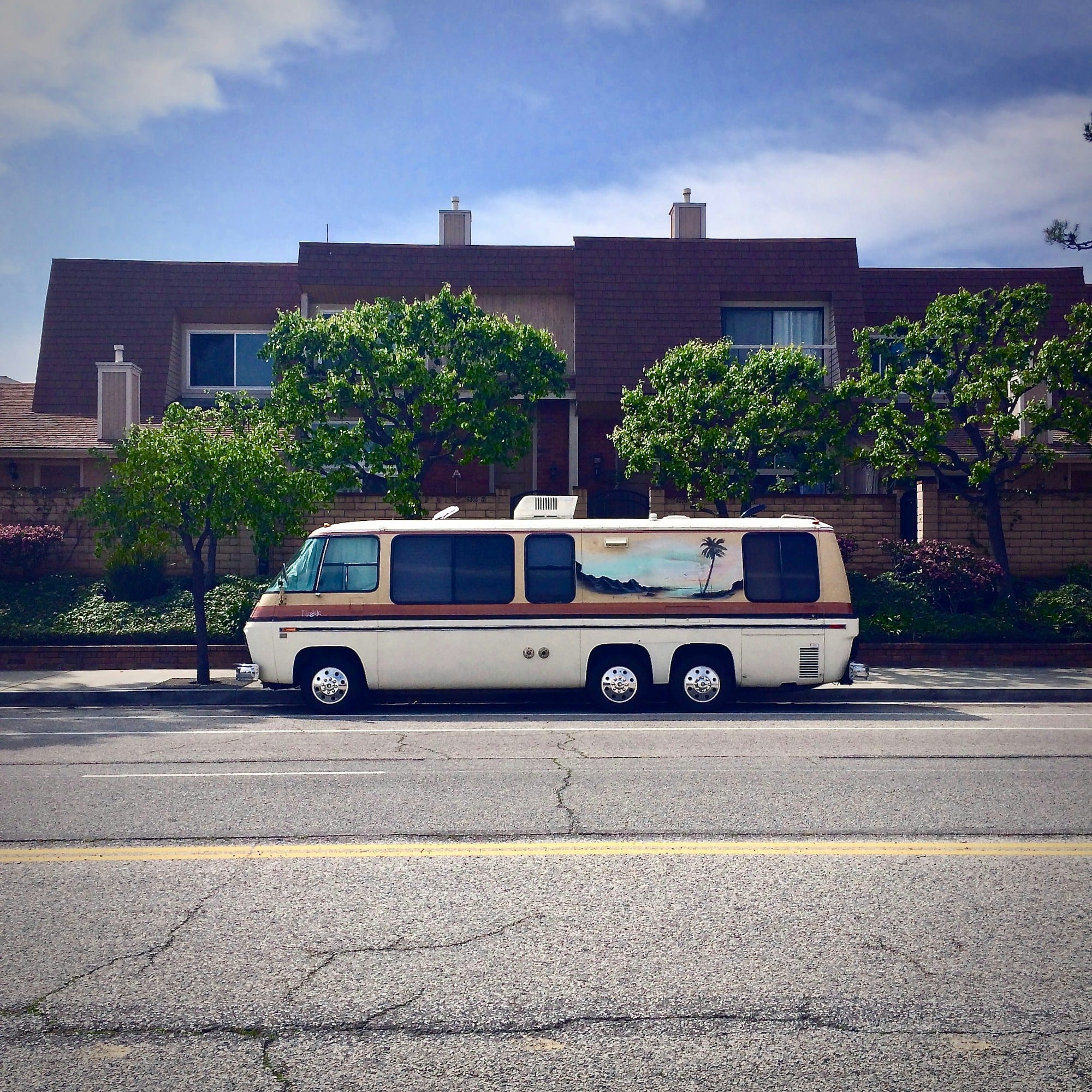 A white service van parked at the curb on a residential street