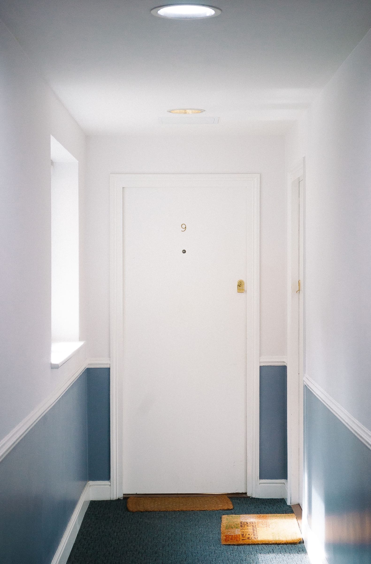 A numbered white apartment door in a residential corridor